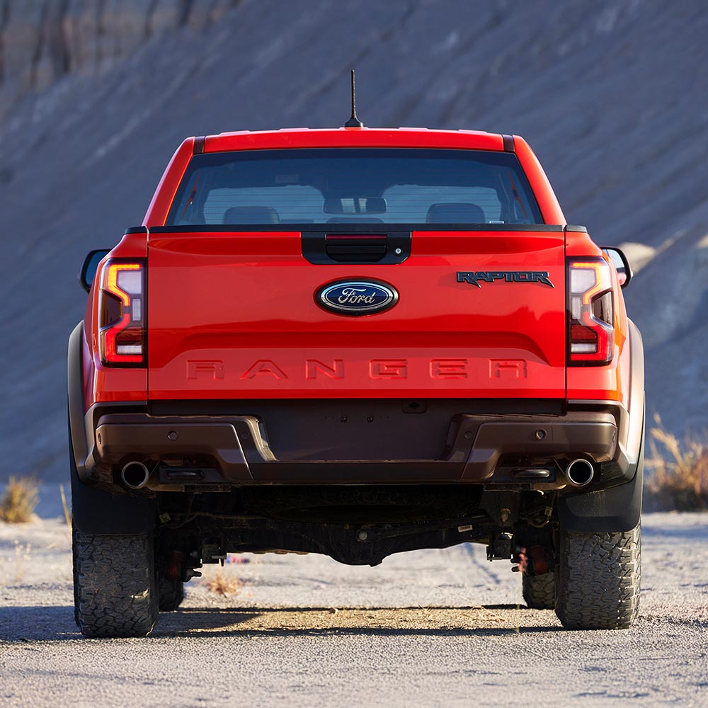 Ford Ranger Raptor i fargen Code orange parkert bakfra.