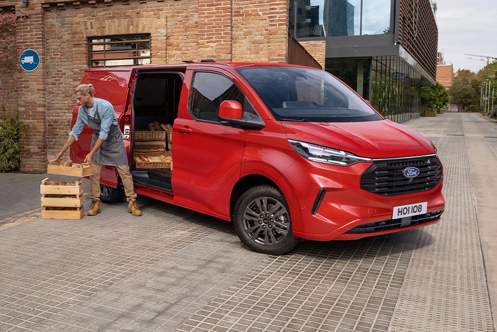 Budsjåfør laster pakker i en rød Ford Transit Custom.