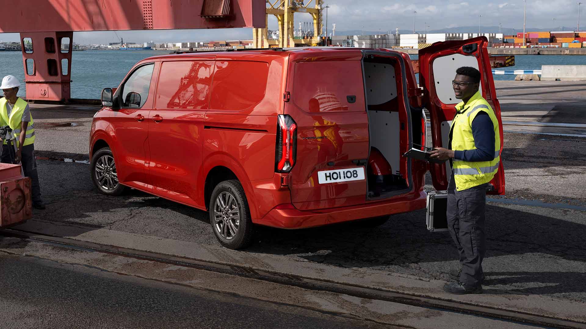 Rød Ford Transit Custom-varebil ved havna.
