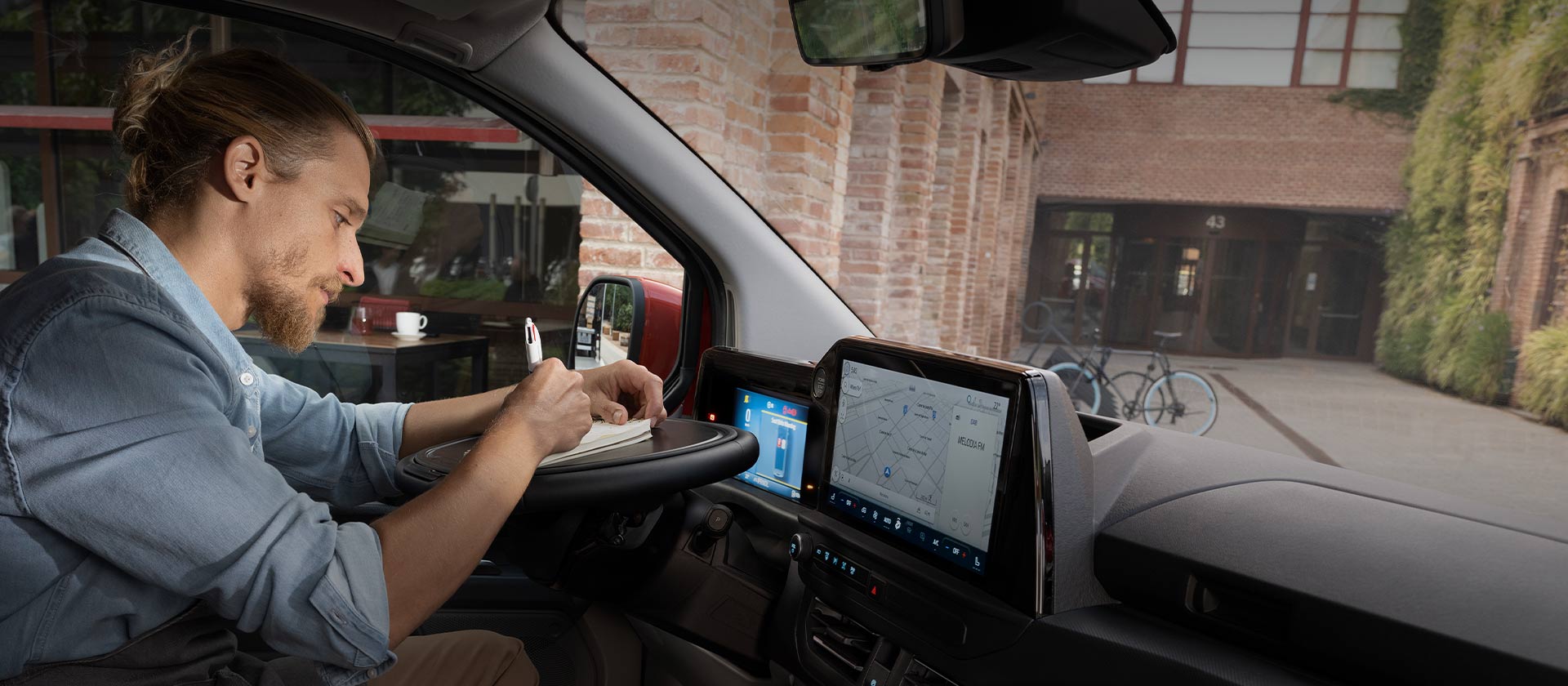 Person som skriver på en laptop inne i en Ford Transit Custom.