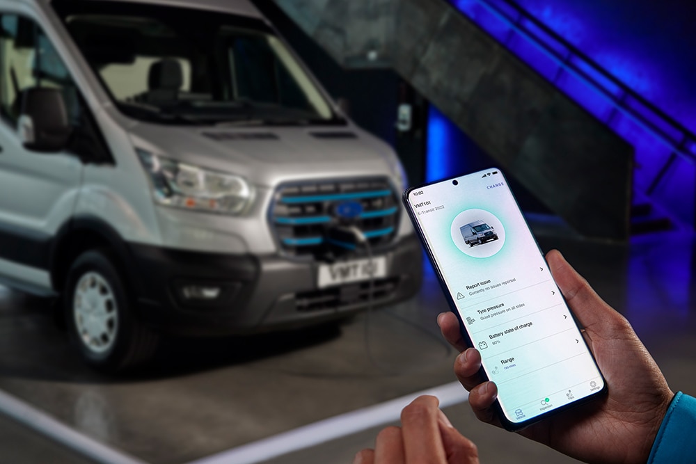 Person som holder en mobiltelefon med Ford Pro informasjon på skjermen.