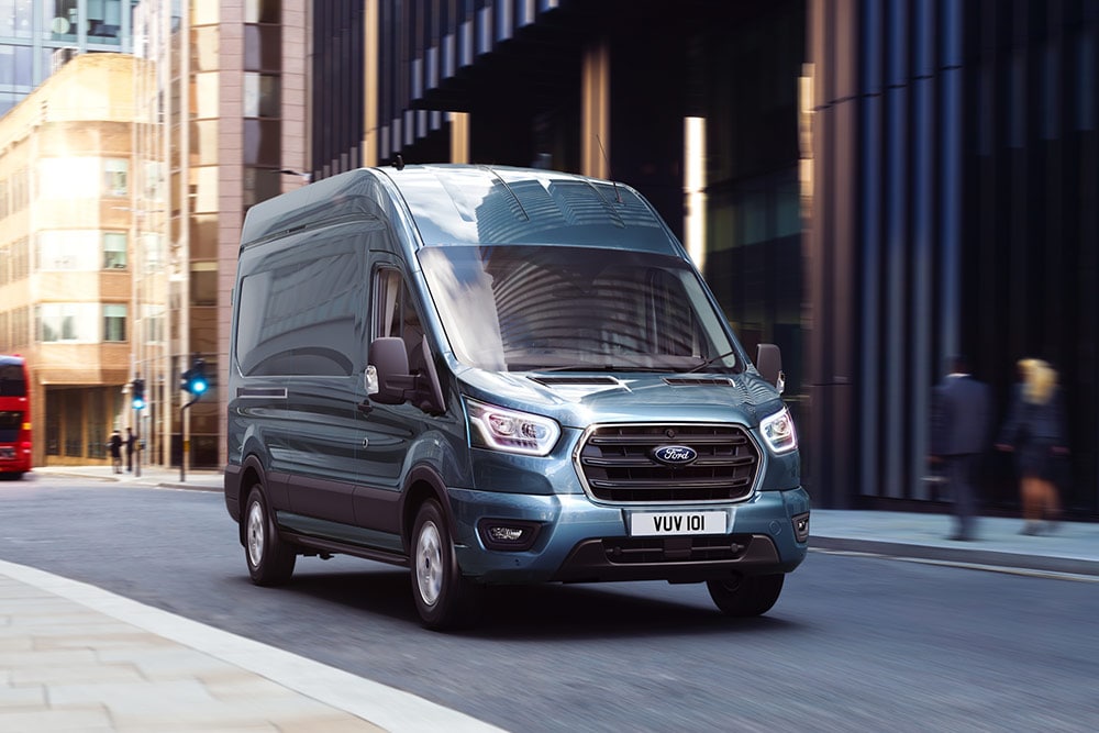 Ford Transit varebil som kjører i byen.