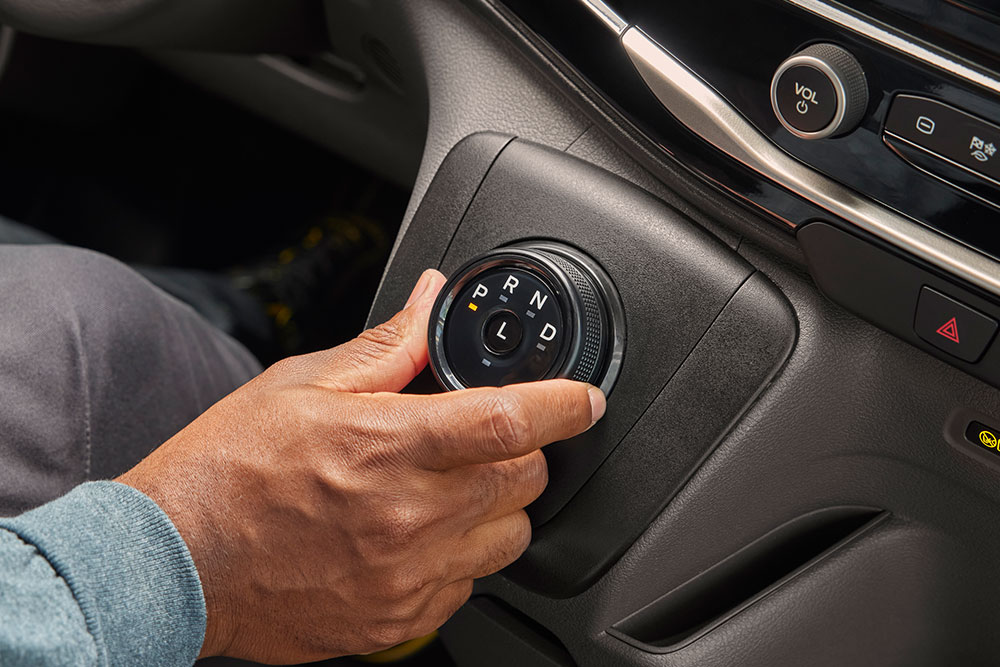 Nærbilde av en hånd som dreier girvelgerknappen i en Ford E-Transit elektrisk varebil.