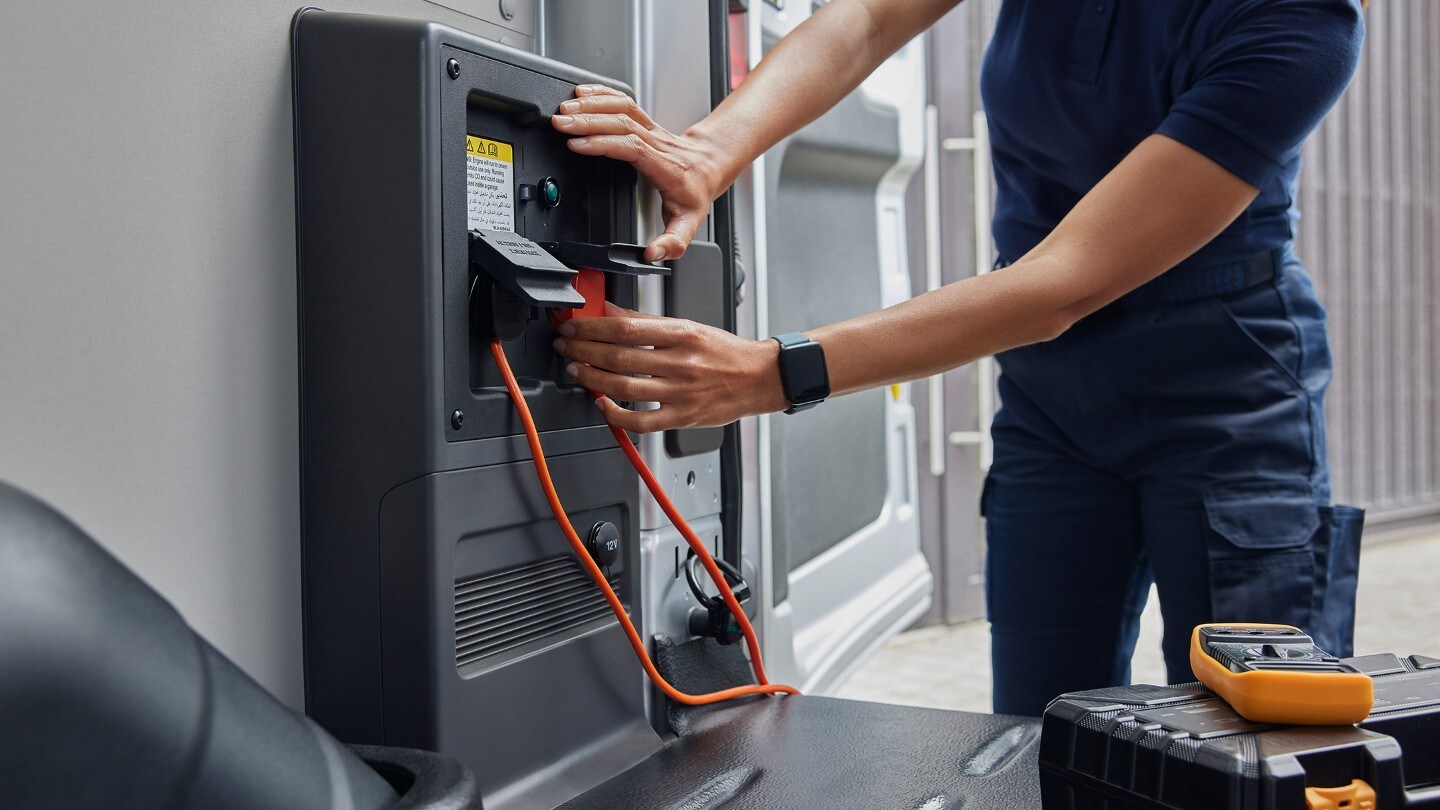 Person plugging in electrical equipment.