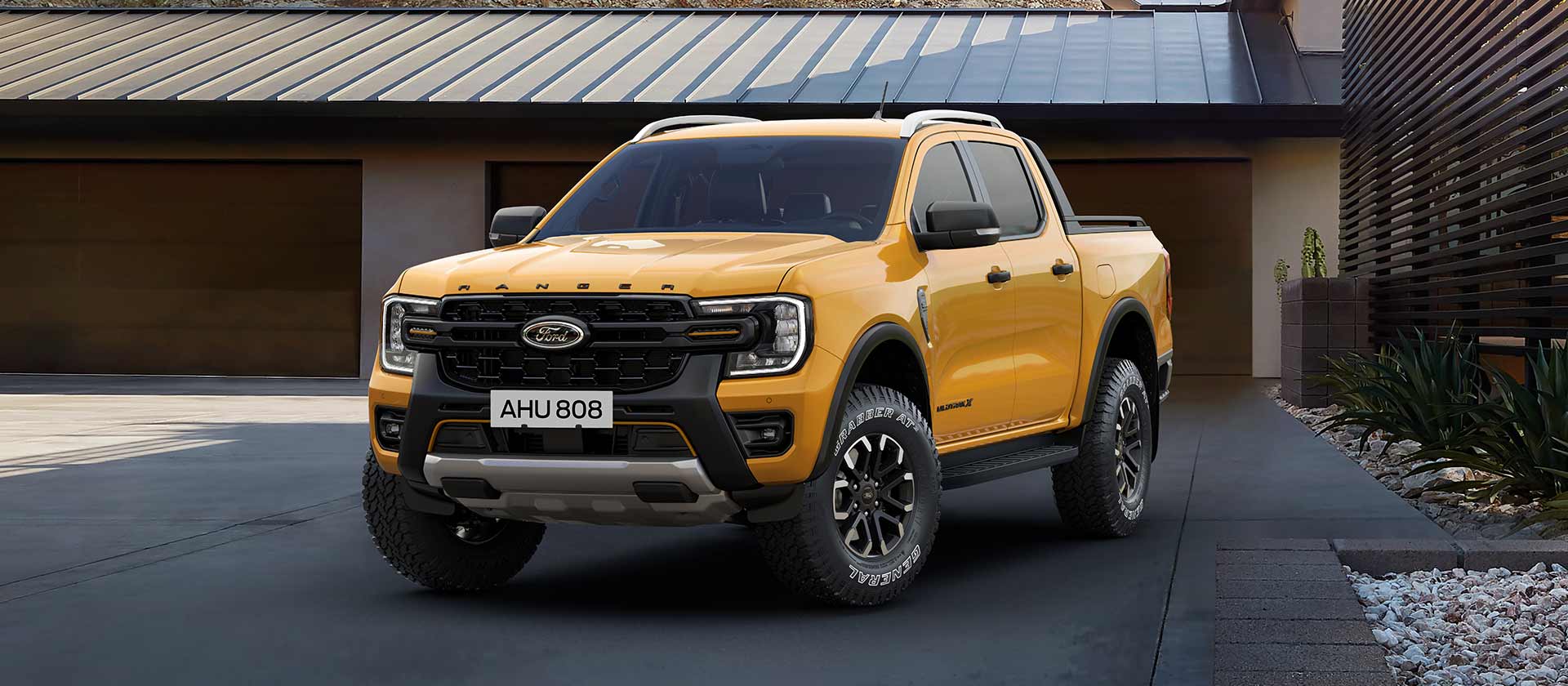 Gul Ford Ranger Double Cab parkert foran et hus.