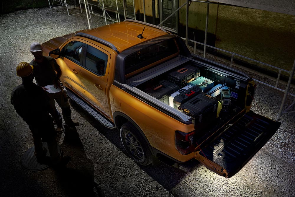 Gul Ford Ranger Wildtrak vist ovenfra om natten med utvendig sonebelysning.