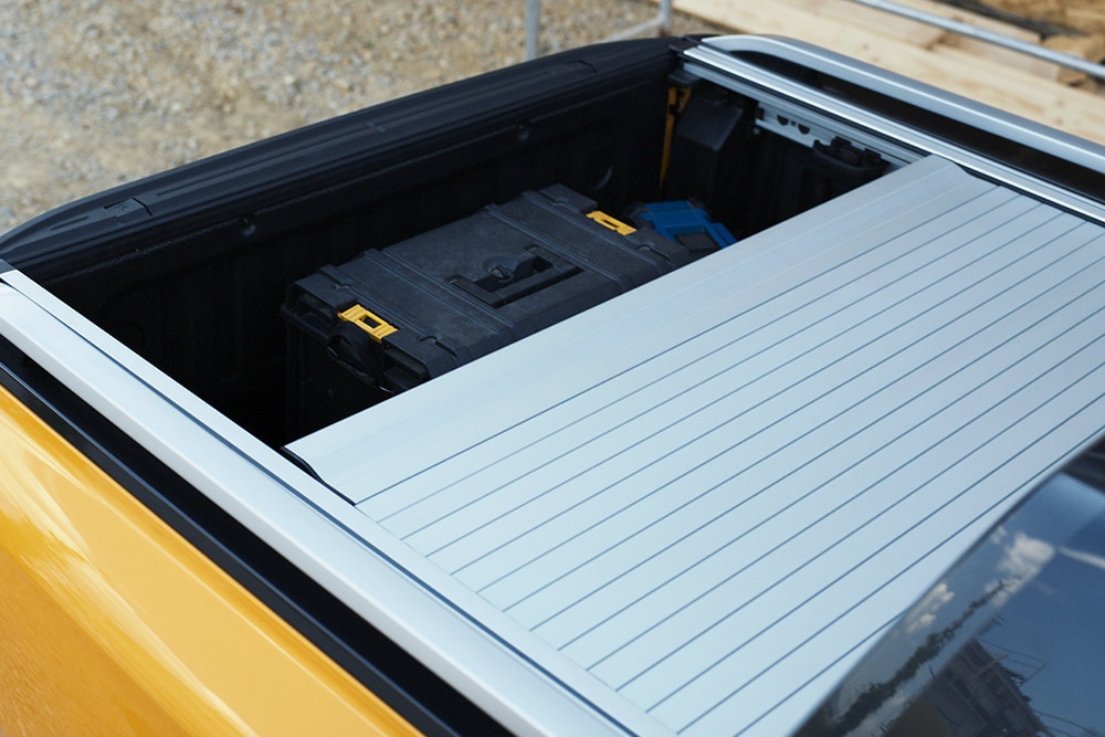 En arbeider som går opp på det integrerte bakre stigtrinnet på Ford Ranger.