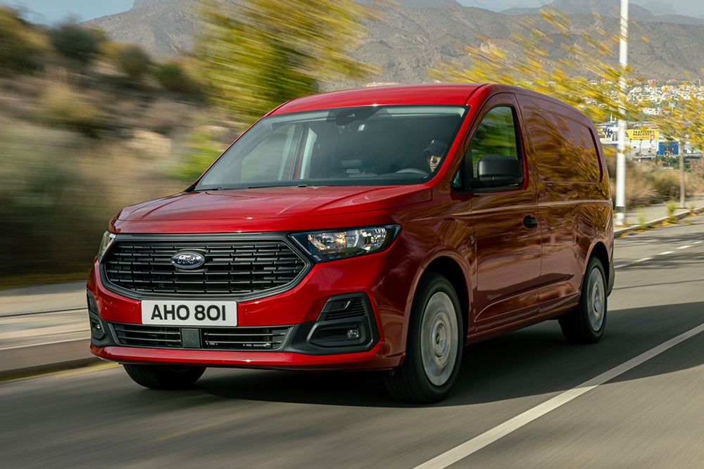 Ford Transit Connect som kjører på en vei, med visning av frontgrill.
