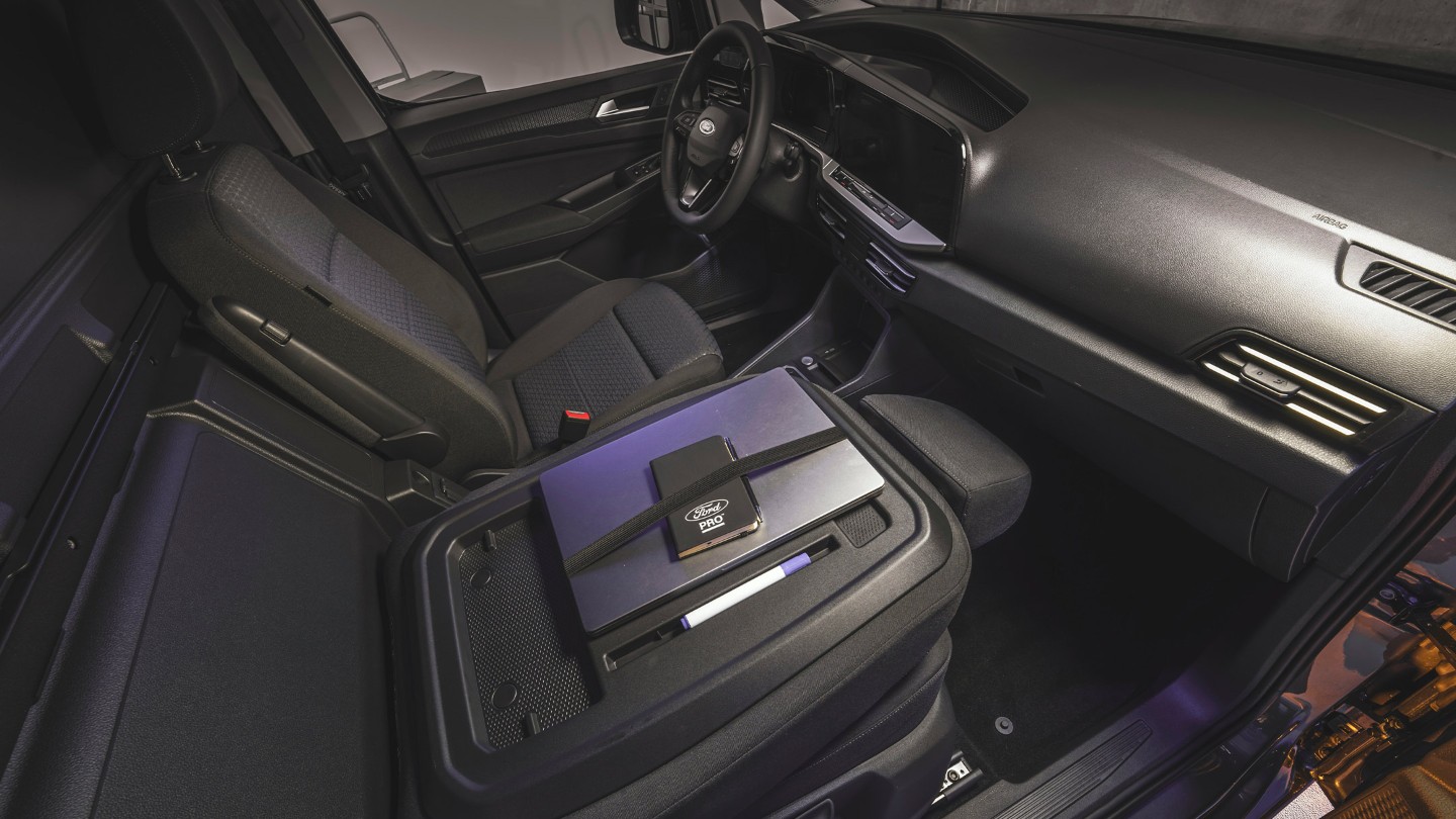 En laptop og Ford Pro-notisbok ligger på arbeidsflatebordet i helt nye Ford Transit Connect.
