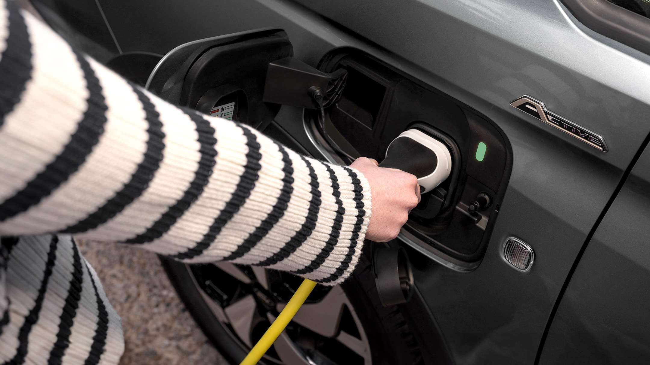 En ladekabel plugget inn i porten på Ford Tourneo Connect i Boundless Blue. 