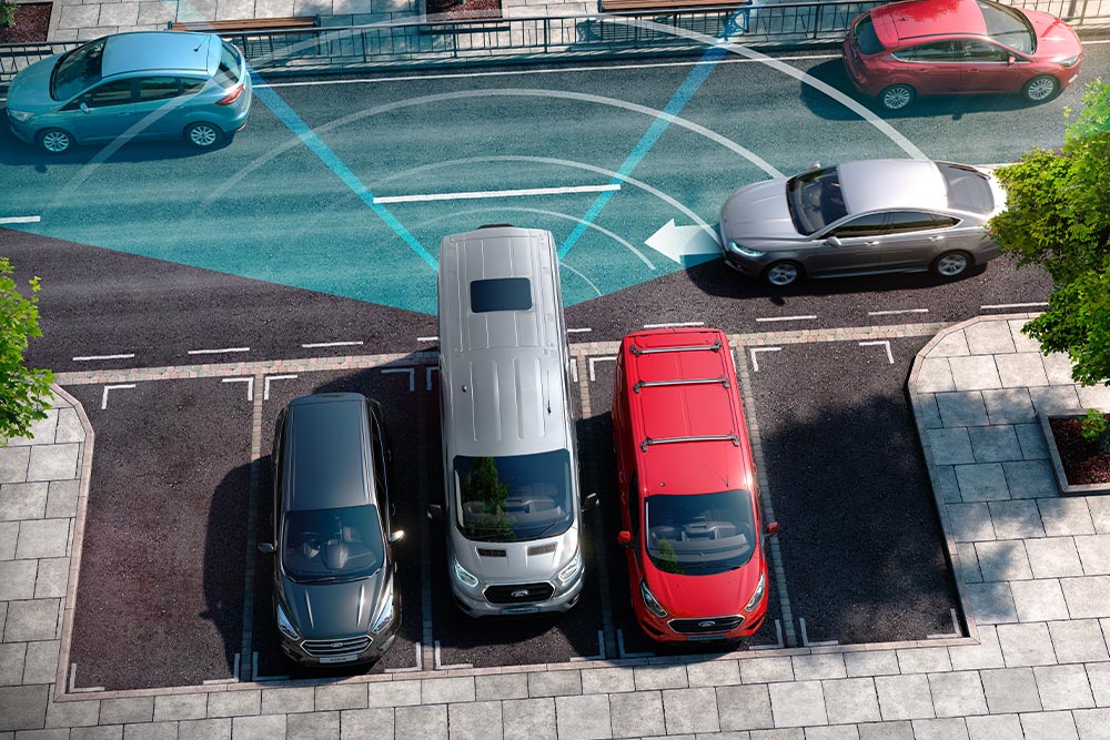 Sølvfarget Ford Transit varebil som rygger, med blå linjer som viser bruk av bakre parkeringssensor . 