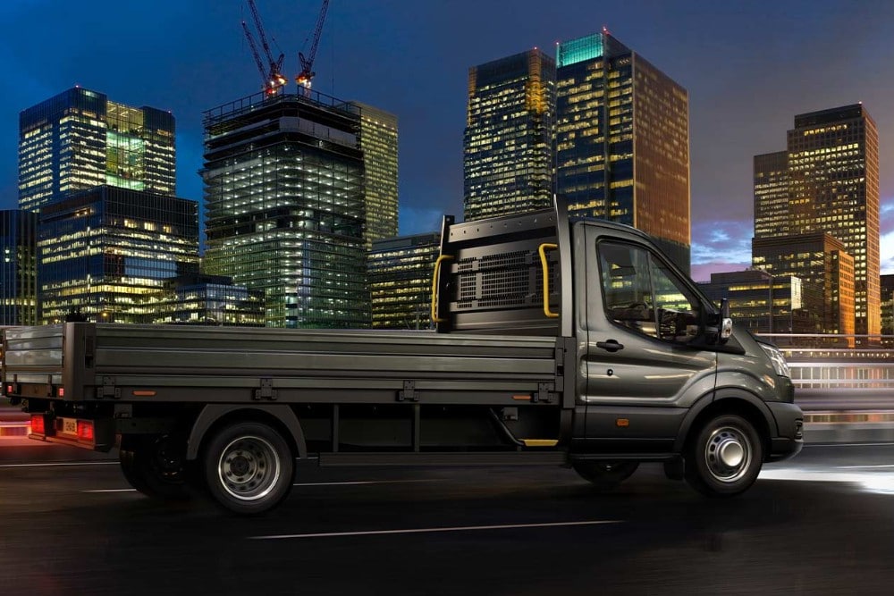 Ford Transit Chassis Cab som kjører langs en bygate om natten. 