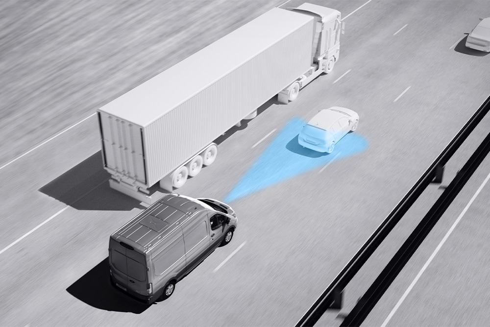 Gråskalategning av en Ford Transit-varebil med blå linjer på veien som viser bruk av avanserte systemer for førerassistanse.