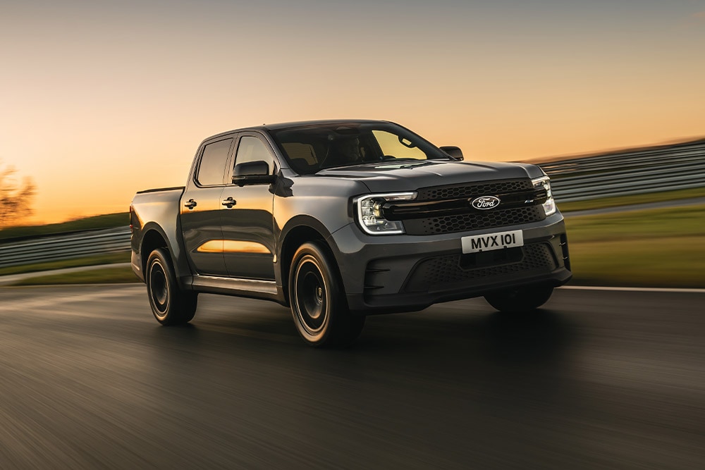 En mørkegrå Ford Ranger Platinum kjører på en bane ved solnedgang.