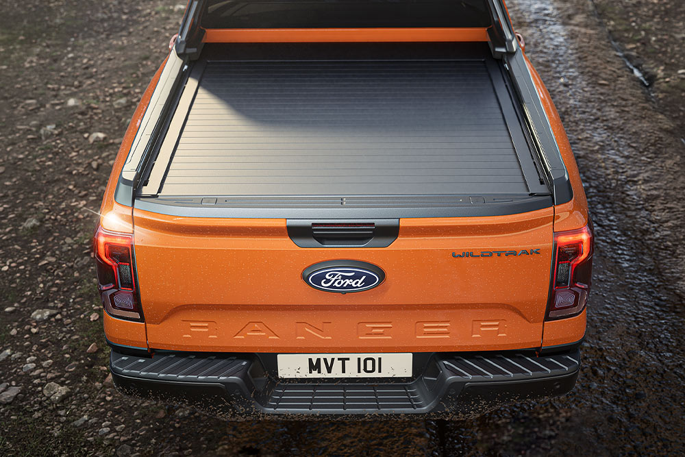 Visning ovenfra av en oransje Ford Rangers lasteplan dekket med presenning.