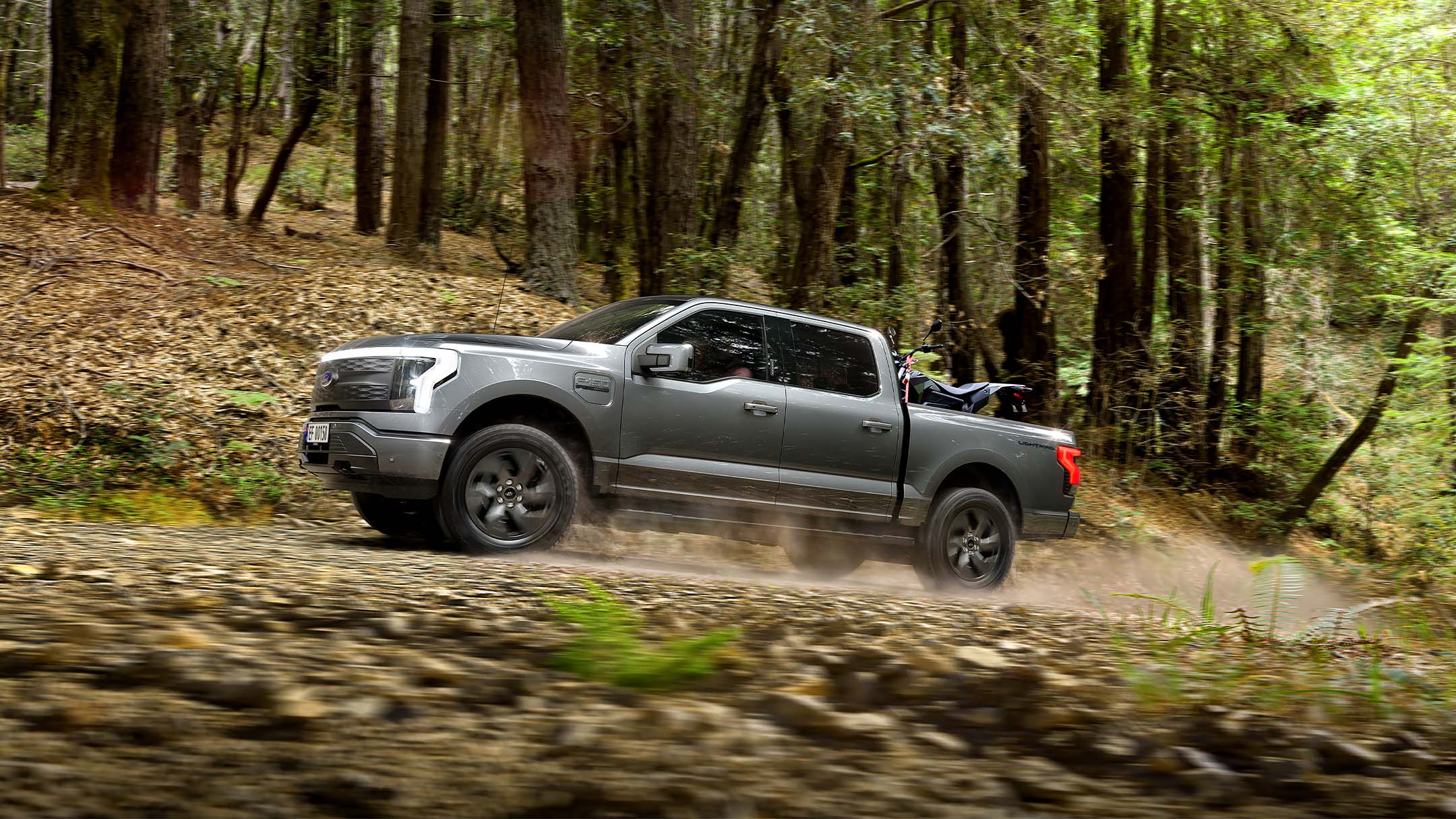 Ford F-150 Lightning driving on forest road