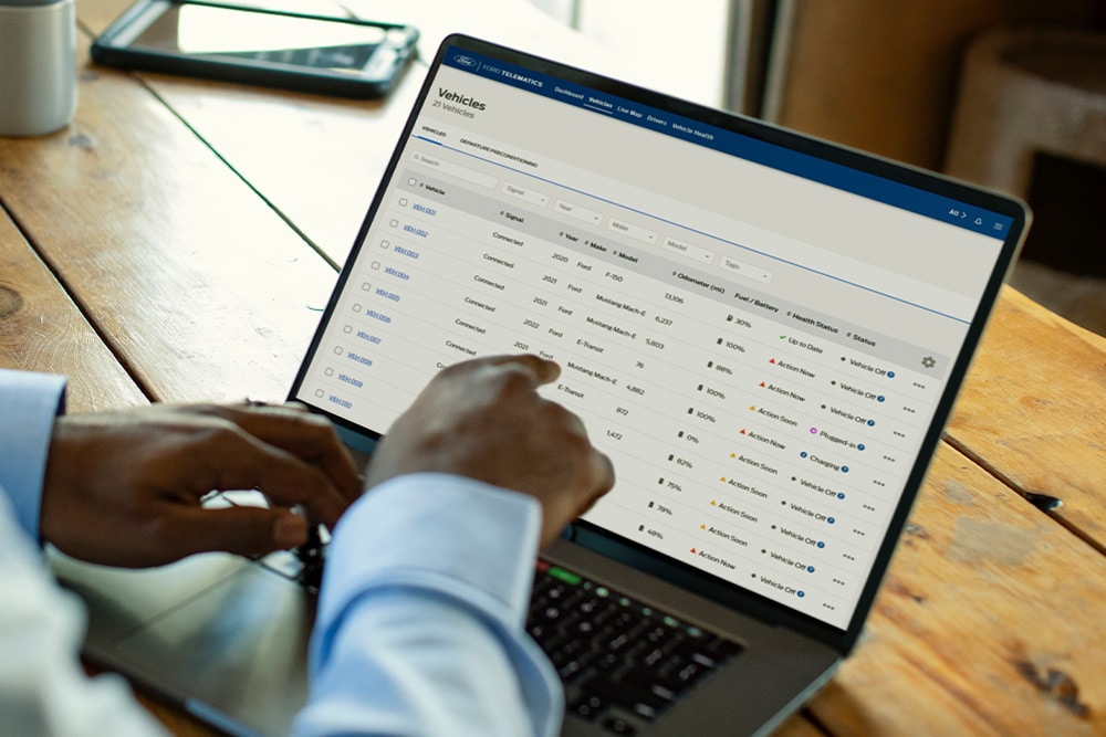 Ford Pro flåtesjef ser på kjøretøydata på sin bærbare datamaskin.