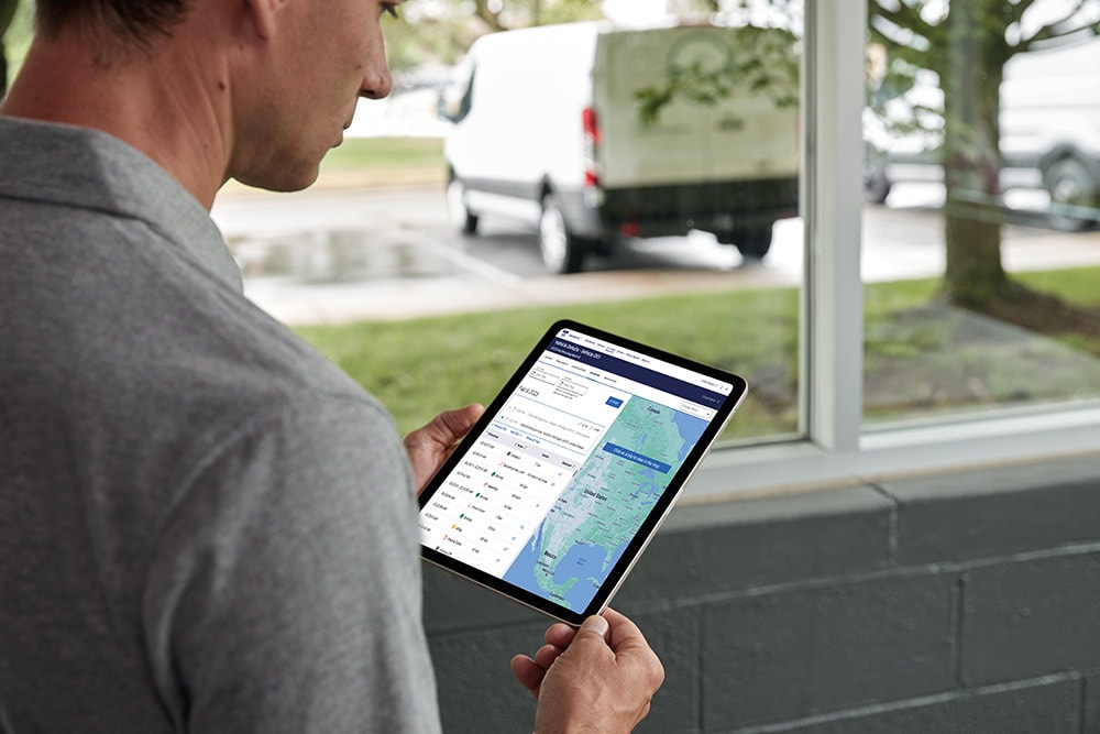 Mann ser på Ford kjøretøydata på et nettbrett, og overvåker det direkte.