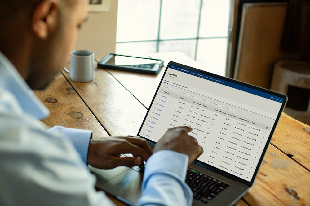 Ford Pro flåtesjef ser på kjøretøydata på sin bærbare datamaskin.