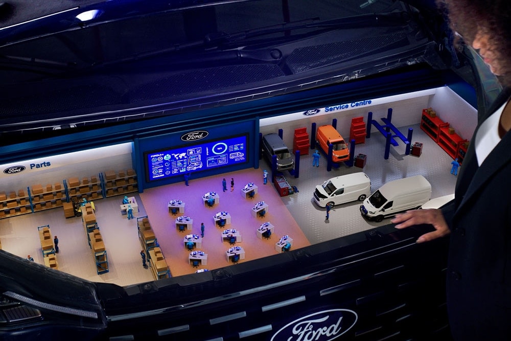 Miniatyrmodell av et Ford servicesenter inne i en bilbagasjerom.