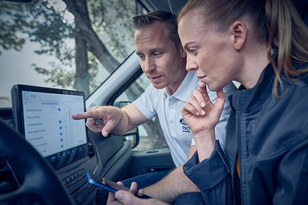 Flere elektriske Ford flåtekjøretøy parkert foran et lager.