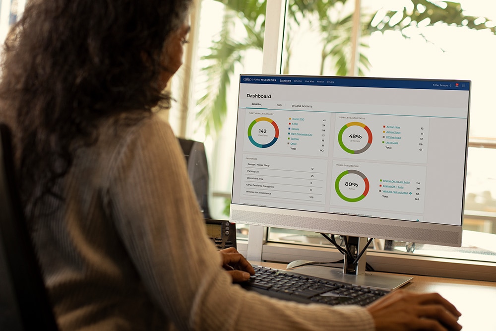  Kvinne ser på Ford Telematics dashborddata på sin stasjonære datamaskin.