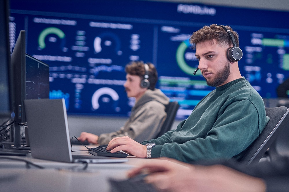  En Ford-ansatt med headset jobber på sin bærbare datamaskin.