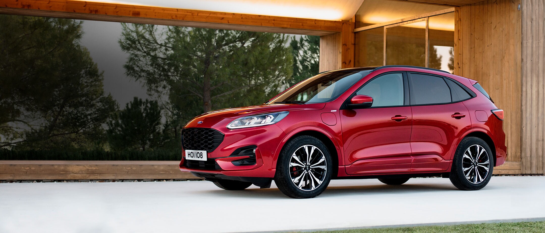 Red Kuga charging in front of a house