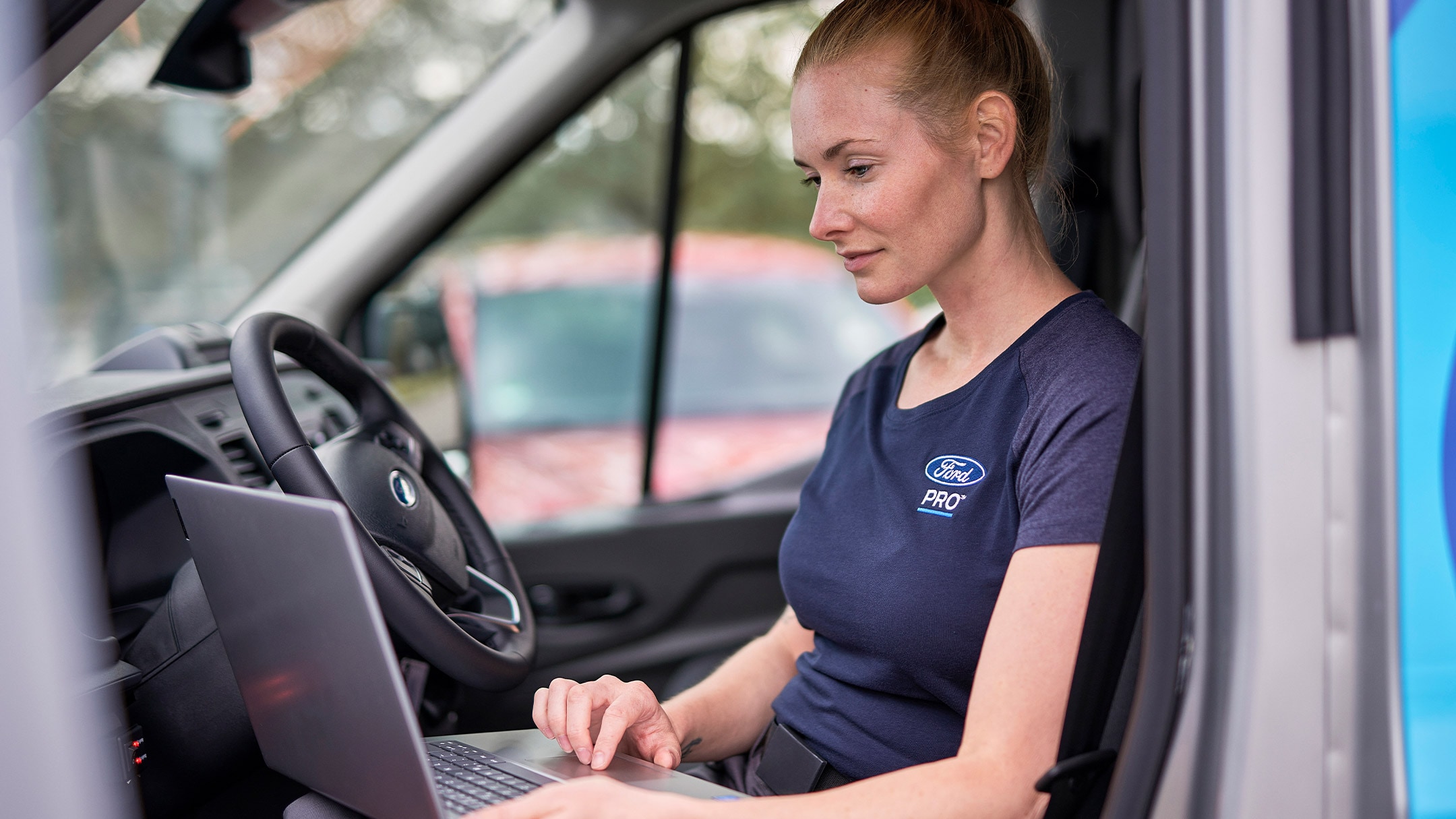 En Ford Pro-mekaniker sjekker en laptop under en Ford Service 