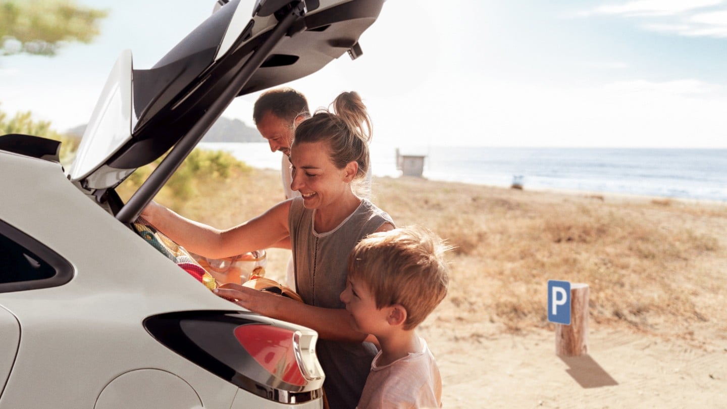 Familie som pakker bagasjerommet på en Ford. 