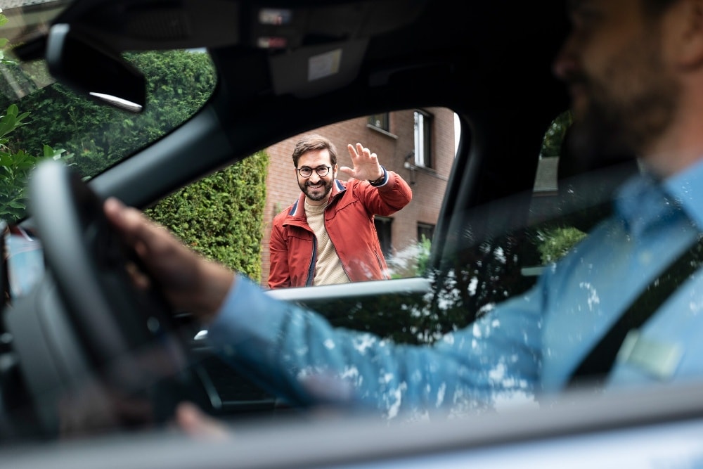 Ford-servicerepresentant med munnbind leverer bil