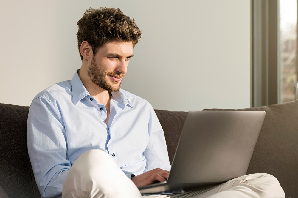 Mann med bærbar PC bruker Ford Online Service Booking