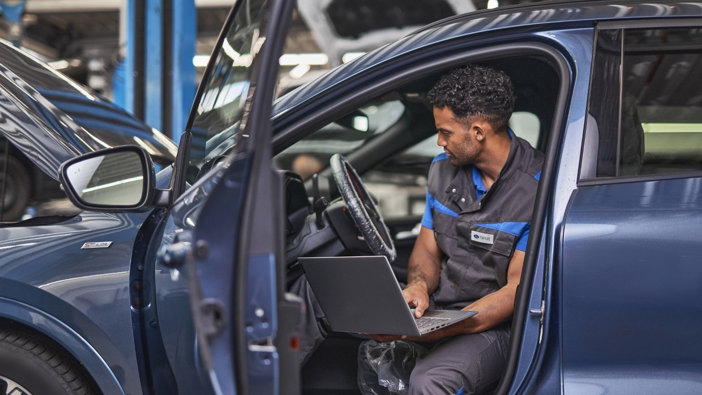 Two Ford Service engineers, inspecting vehicle Two Ford Service engineers, inspecting vehicle