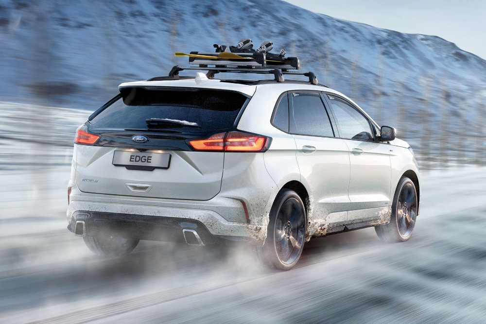 Hvit Ford Edge som kjører på isete veier