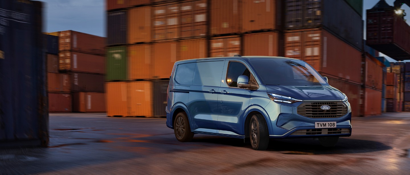 Transit Custom ladbar hybrid kjørende i et havneområde.